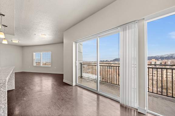 A room with a large window and a balcony overlooking a construction site. at Wilmington Flats Apartments, Salt Lake City, UT, 84106