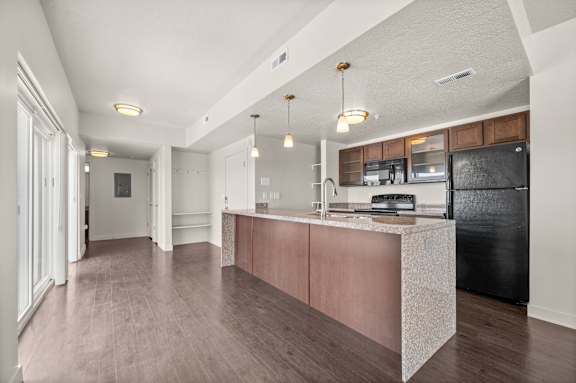 A kitchen with a black fridge and wooden cabinets. at Wilmington Flats Apartments, Salt Lake City, 84106