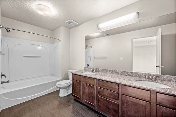 A bathroom with a white tub, sink, and toilet. at Wilmington Flats Apartments, Utah