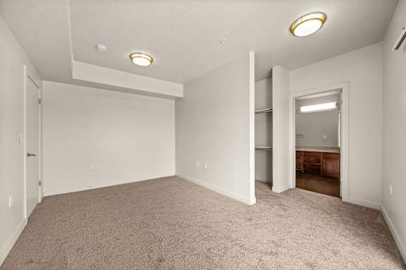 A spacious room with carpeted floor and white walls. at Wilmington Flats Apartments, Utah, 84106