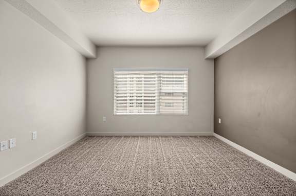 A room with a carpeted floor and a window with blinds. at Wilmington Flats Apartments, Salt Lake City