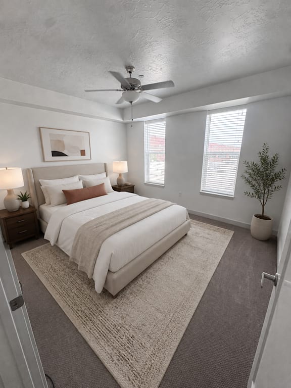 A bedroom with a large bed and a ceiling fan.
