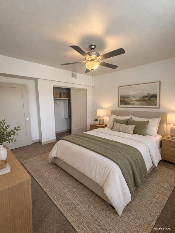 A bedroom with a bed, nightstand, and a ceiling fan.