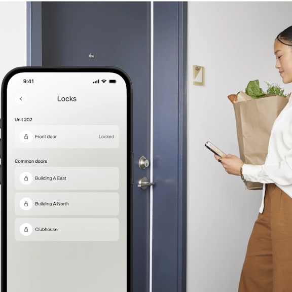 A woman is holding a smartphone and looking at a lock screen application.