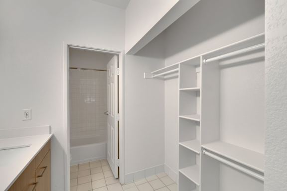 Walk in closet with white shelving1 at AVIA Apartments On Alpha, Dallas