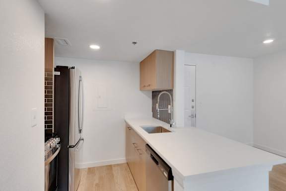 Kitchen with white counter top and refrigerator1 at AVIA Apartments On Alpha, Dallas, TX, 75240