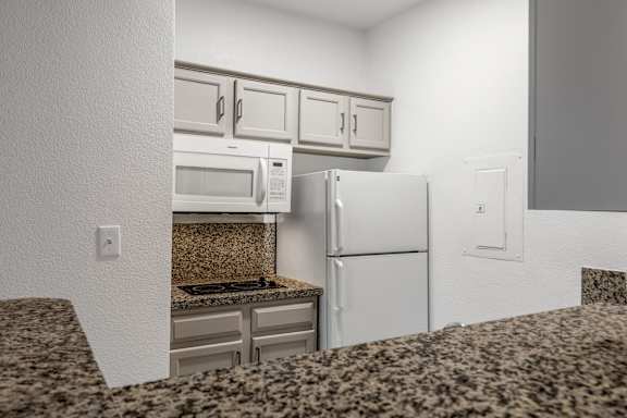 Kitchen with white appliances5 at AVIA Apartments On Alpha, Texas