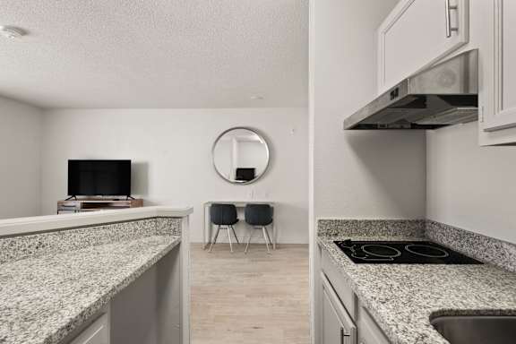 A kitchen with granite countertops and a stove top oven.