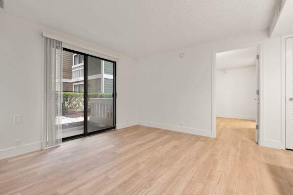 White modern empty living room with wooden floor at AVIA Lofts on Parkway, Washington