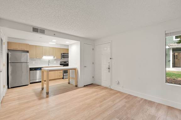 Living room with attached kitchen and window at AVIA Lofts on Parkway, Vancouver, WA