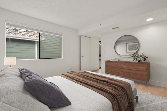 Bright bedroom with sleek mirror at AVIA Lofts on Parkway, Vancouver, WA