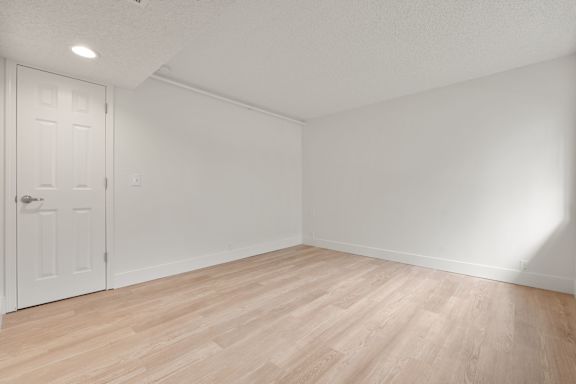 Empty room with white door and wooden floor at AVIA Lofts on Parkway, Vancouver Washington
