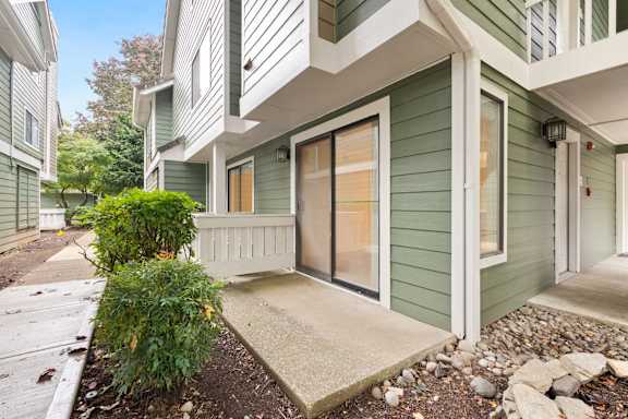 A green house with a white door and windows. at AVIA Lofts on Parkway, Vancouver Washington