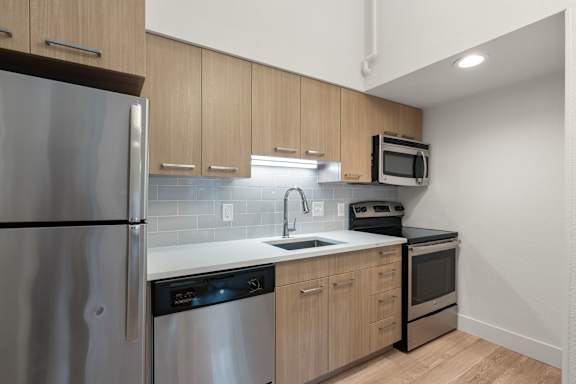 Kitchen interior with wooden cabinet styling at AVIA Lofts on Parkway, Vancouver, WA