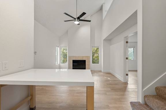 A white table is in a room with a fireplace and a ceiling fan. at AVIA Lofts on Parkway, Washington