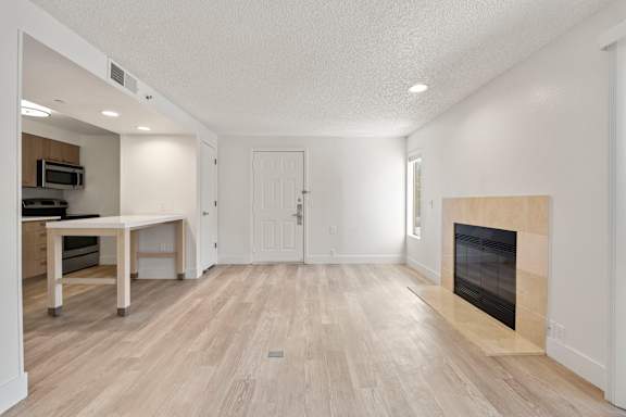 spacious living room with a fireplace and a dining area with grey floorat AVIA Lofts on Parkway, Vancouver, 98662