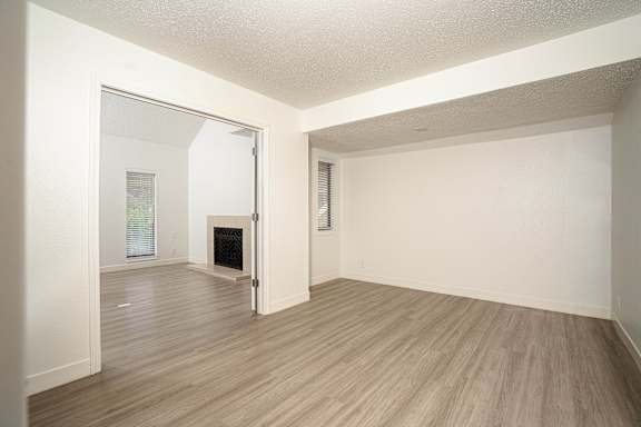 Room with a fireplace and wood flooring at AVIA Lofts on Victors Way, Ann Arbor