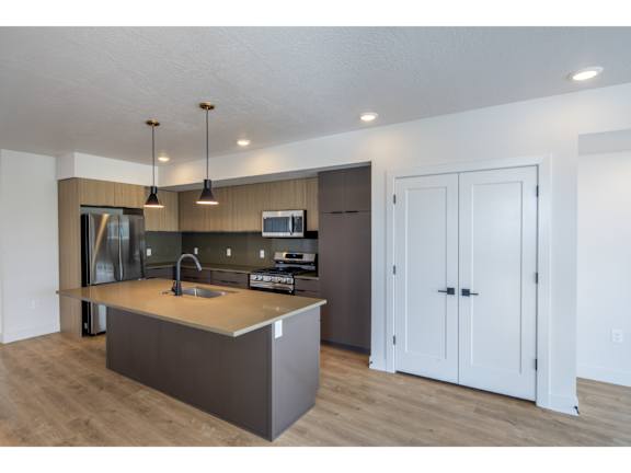 Open kitchen with island and pendant lighting at Brickside Heights Apartments, Utah, 84106