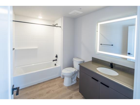 Modern bathroom with lighted mirror and vanity at Brickside Heights Apartments, Millcreek, UT