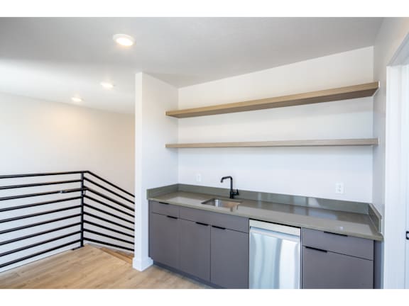Wet bar with floating shelves and metal railing at Brickside Heights Apartments, Millcreek, Utah