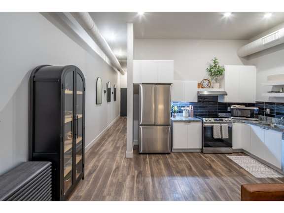 A modern kitchen with a refrigerator, oven, and stove.