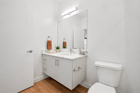 A white bathroom with a toilet, sink, and medicine cabinet.
