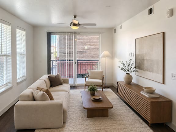 A living room with a large couch, a chair, a coffee table, and a painting on the wall.