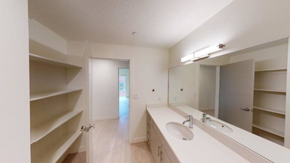 A white bathroom with a sink, mirror, and shelves. at Paperbox Lofts Apartments, Apartments, Salt Lake City  , UT