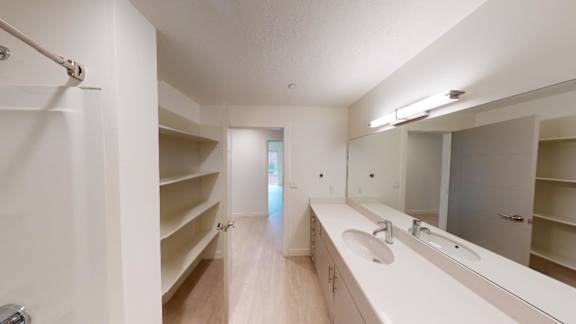 A bathroom with a sink, mirror, and shelves. at Paperbox Lofts Apartments, Utah, 84101
