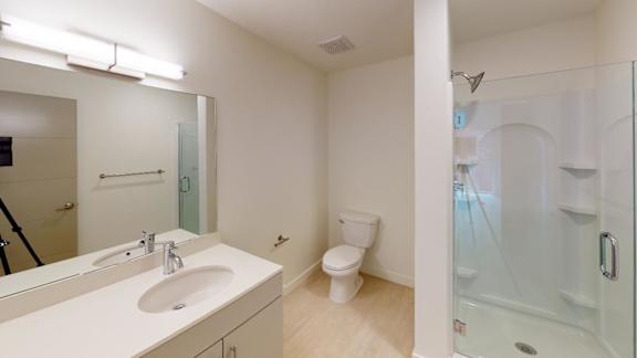 A white bathroom with a sink, toilet, and shower. at Paperbox Lofts Apartments, Salt Lake City  , UT, 84101
