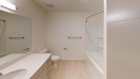 A white bathroom with a toilet, sink, and shower. at Paperbox Lofts Apartments, Salt Lake City  , UT, 84101