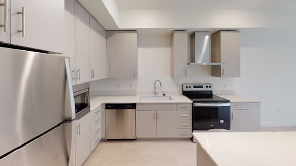 A modern kitchen with stainless steel appliances and white cabinets. at Paperbox Lofts Apartments, Salt Lake City  , 84101