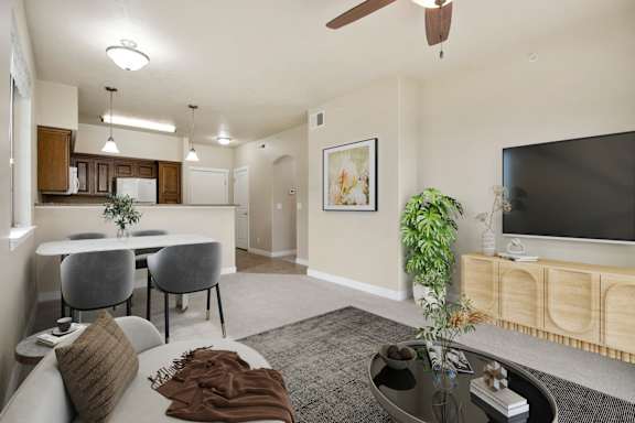A living room with a grey couch and a television at Siena Villas Apartments, Orem, 84097