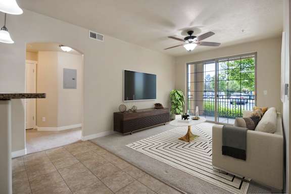 A living room with a flat screen TV and a large window at Siena Villas Apartments, Utah, 84097