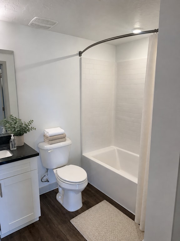 A white toilet sits next to a white bathtub in a bathroom.