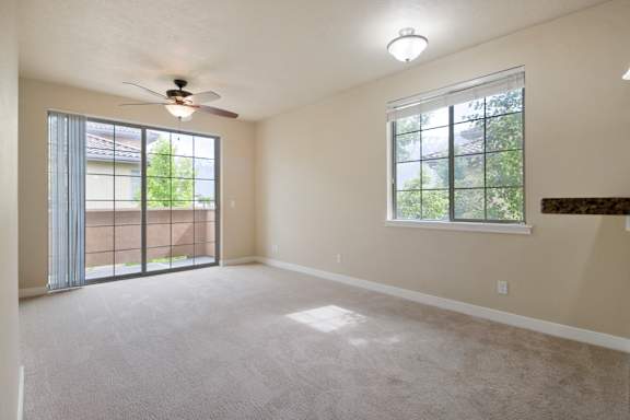 A room with a ceiling fan and a window with a view of trees. at Siena Villas Apartments, Orem, Utah