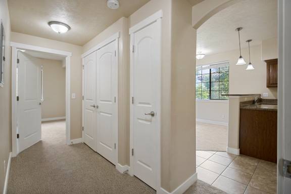 A hallway with white doors and a tiled floor. at Siena Villas Apartments, Apartments, Orem, UT