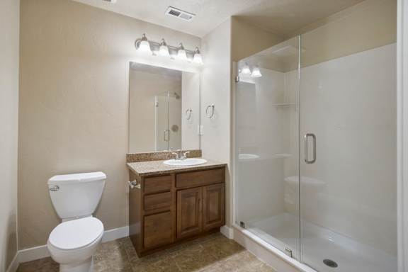 A bathroom with a toilet, sink, and shower. at Siena Villas Apartments, Orem