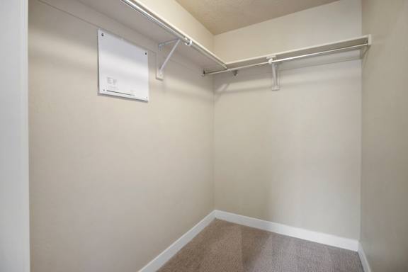 A white metal shelf is mounted on a wall. at Siena Villas Apartments, Orem, Utah