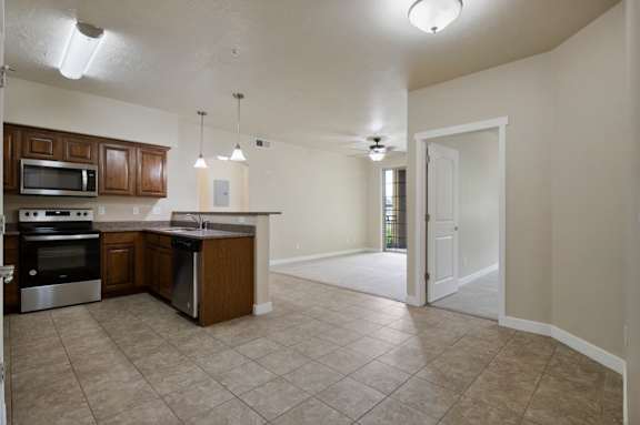 A kitchen with brown cabinets and a white door. at Siena Villas Apartments, Orem, 84097