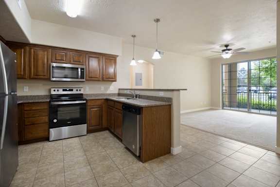 A kitchen with brown cabinets and a black refrigerator. at Siena Villas Apartments, Orem, UT, 84097