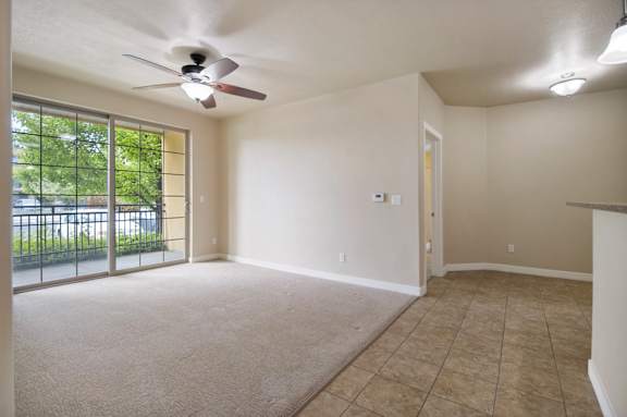 A room with a ceiling fan and sliding glass doors at Siena Villas Apartments, Utah