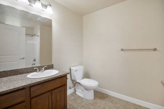 A white toilet sits in a bathroom next to a sink at Siena Villas Apartments, Utah