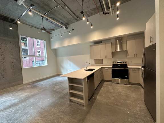 A kitchen area with a stove, sink, and refrigerator at Paperbox Lofts Apartments, Salt Lake City  , Utah