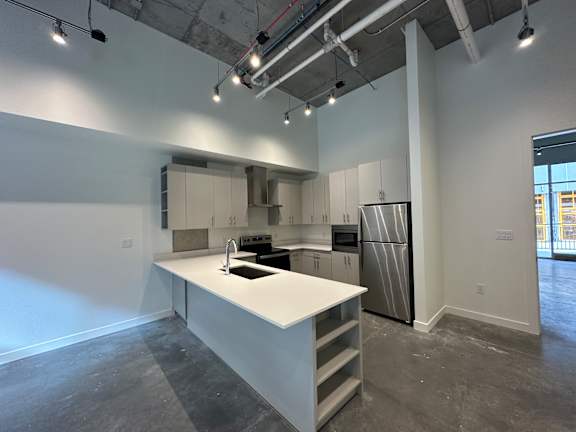 A kitchen with white cabinets and a white island at Paperbox Lofts Apartments, Salt Lake City  , 84101