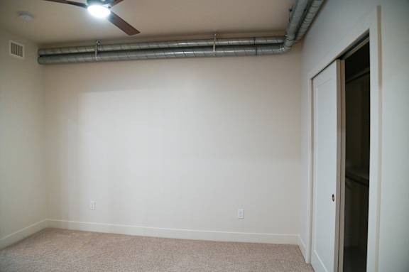 A room with a ceiling fan and a door.