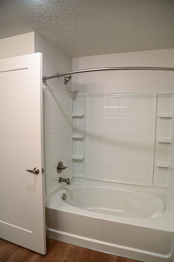 A white bathroom with a tub and shower.