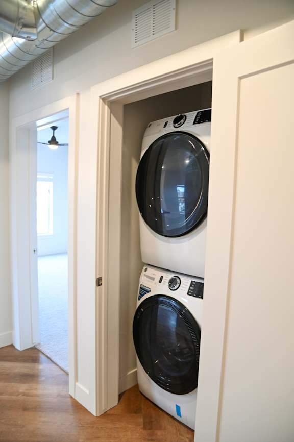 Stacked washer and dryer in hallway closet at The Revival Apartments, Utah