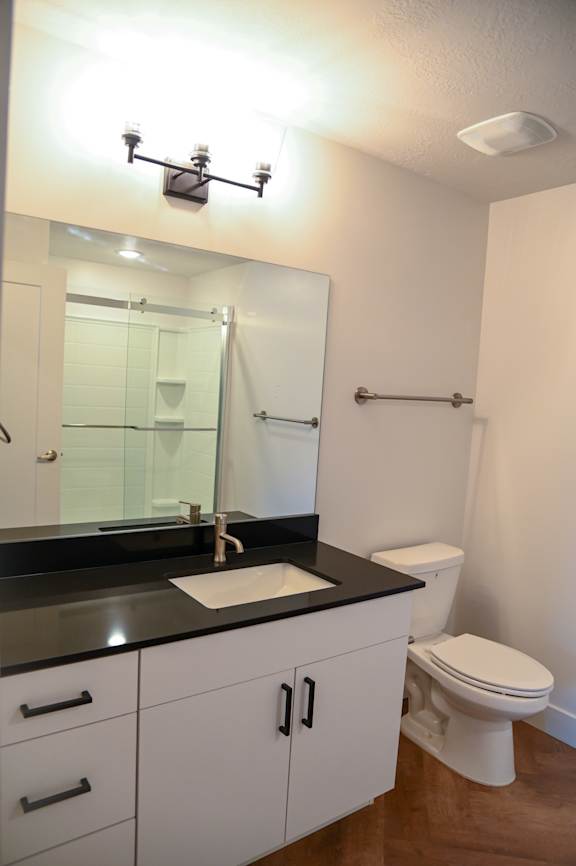 Bathroom with white vanity and glass shower door at The Revival Apartments, Utah, 84101