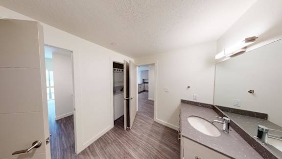 A bathroom with a sink, mirror, and toiletries. at Paperbox Lofts Apartments, Salt Lake City  , UT, 84101